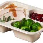 Compostable food tray with Hot Turkey Mashed Potatoes Gravy Cranberries Brussel Sprouts