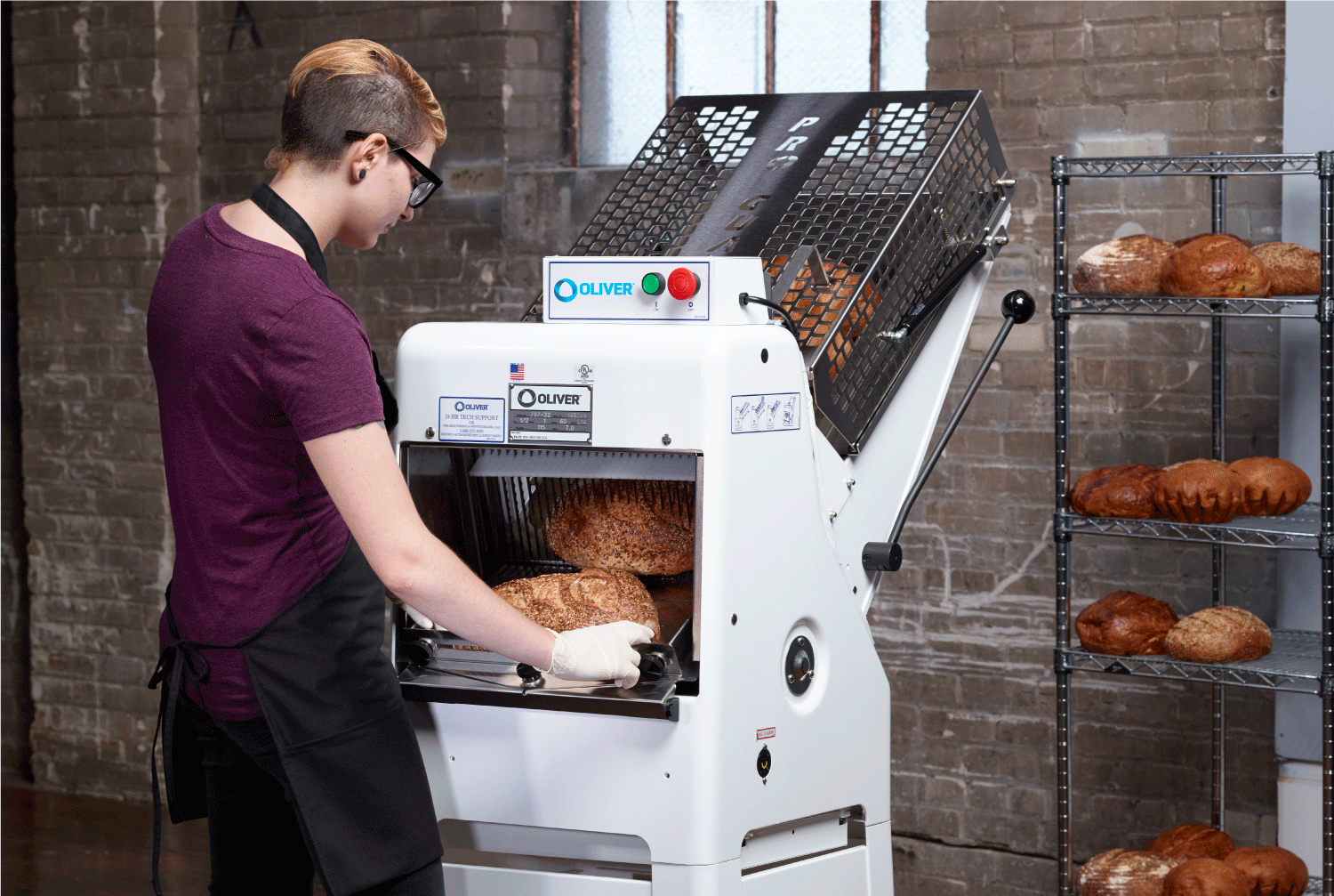 Woman using Oliver's Gravity Feed bread slicers to slice loaves of artisan bread