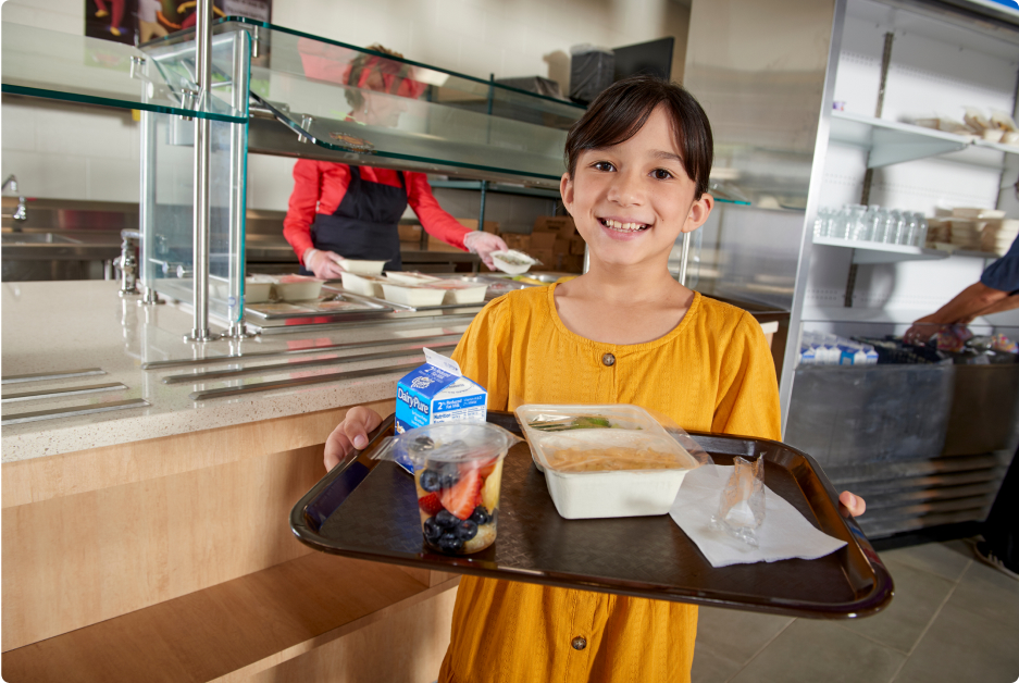 School nutrition in a tray. Child with a school lunch in an Oliver Packaging tray