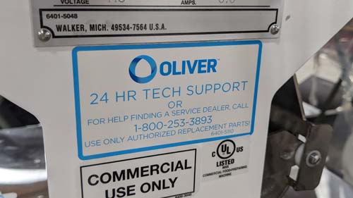 Labels on bakery equipment showing origin of machine and contact information for 24 hour tech support.