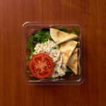 1 Compartment Plastic Cold Tray containing Tuna Salad, a Tomato slice & Pita pieces lid top view