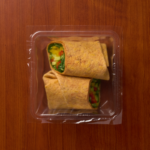 1 Compartment Plastic Cold Tray with Insert containing a Veggie Wrap with film lid top view